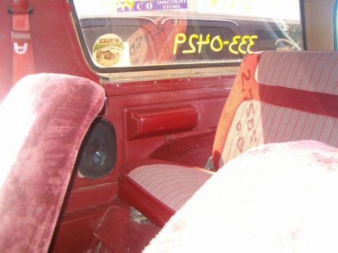 1985 Ford Bronco - Interior of a 1985 Ford Bronco, red seats and a sticker on the rear window.