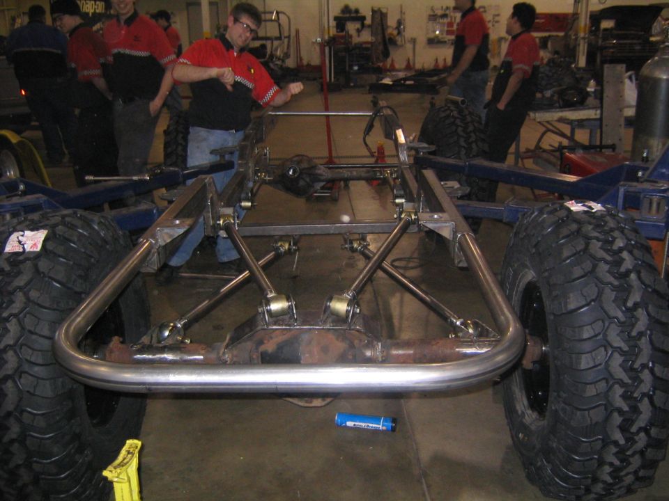 Vehicle frame with large off-road tires and suspension components, under construction