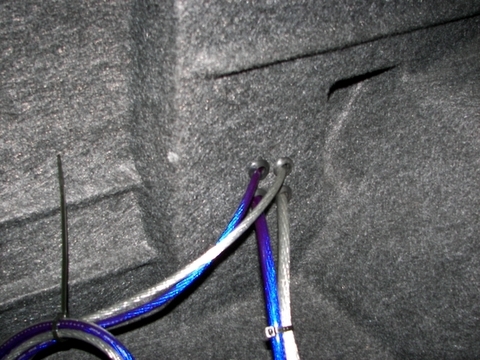 2000 Ford Taurus - Audio System Installation - Amplifier Power and Ground wires fed through grommets in left rear wheel well cover
