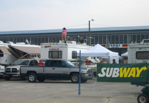 1979 Ford F-150 - A scene with RVs and a pickup truck, a person is standing on top of an RV.