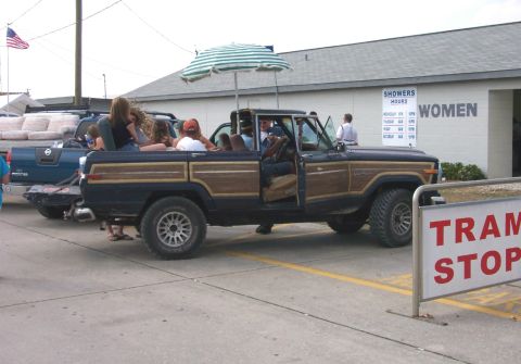 1979 Ford F-150 - This wood-paneled SUV, possibly a 1979 model, is seen with passengers enjoying an umbrella on a sunny day.