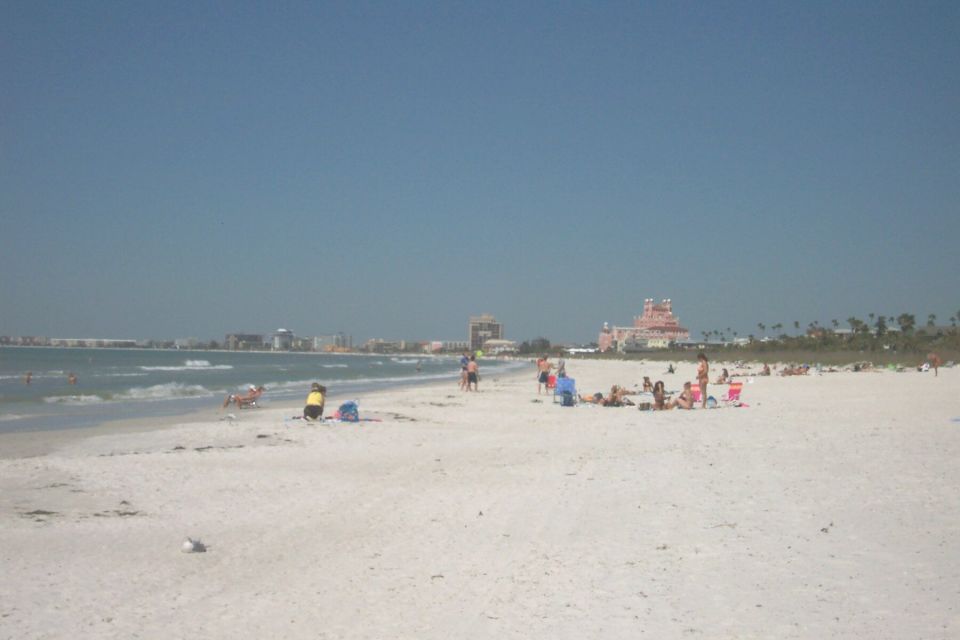 Beach scene with people sunbathing and buildings in the distance