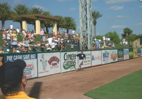 1979 Ford F-150 - A baseball game is in progress with fans in the stands and advertising along the outfield wall.