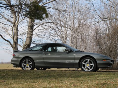 1996 Ford Probe - Side view of a gray 1996 Ford Probe coupe on a grassy field.
