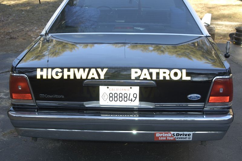 Rear of a 1991 Ford Crown Victoria police car with "HIGHWAY PATROL" on the trunk and a California license plate