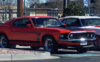 1972 Ford Ranchero - A red 1969 Ford Mustang Boss 302 is parked next to another vehicle.