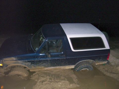 1992 Ford Bronco - This 1992 Ford Bronco is deeply stuck in mud, with its tires submerged.