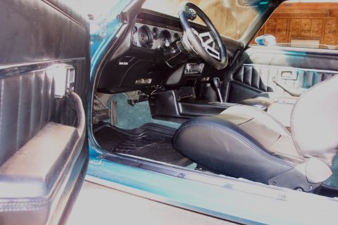 1979 Pontiac Trans Am - The interior of a teal 1979 Pontiac Trans Am shows black seats, dashboard, and door panels.