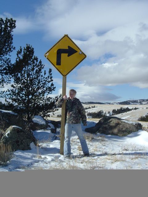 1989 Ford Bronco - A person poses with a directional road sign in a snowy, rural landscape.