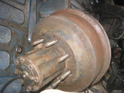 1986 Ford Bronco - A close-up view of a rusty brake drum and hub assembly from a vehicle.
