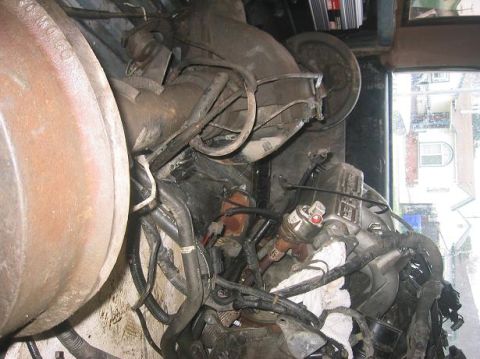 1986 Ford Bronco - Close-up view of a cluttered engine compartment with various mechanical parts and wiring visible.