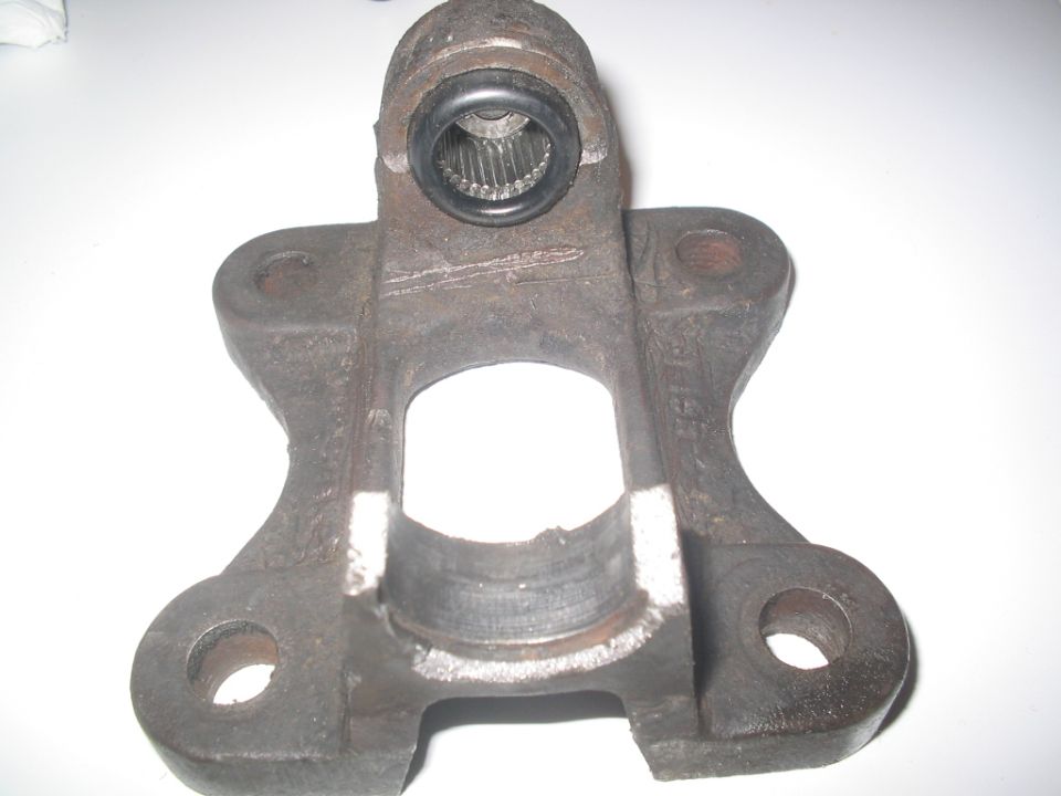 Close-up of a rusty metal automotive part with splines visible inside a circular opening
