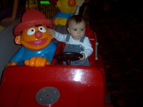2004 Ford F-150 - A baby sits in a toy fire truck with a Sesame Street character, likely at an amusement venue.