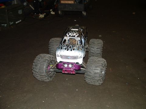 1994 Ford Bronco - A remote control monster truck with custom flame paint sits on a garage floor.