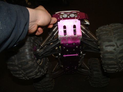 1994 Ford Bronco - Close-up of a remote control car's underside, showing its suspension and large tires.