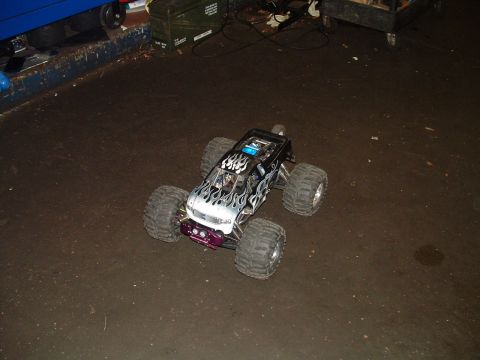 1994 Ford Bronco - A remote control monster truck with flame graphics sits on a garage floor.