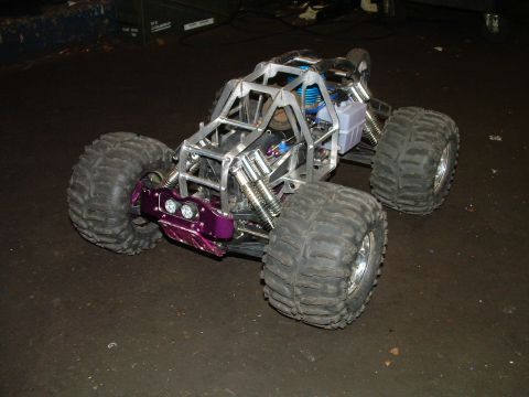 1994 Ford Bronco - This custom-built RC car features a distinctive purple front bumper, a prominent roll cage, and oversized off-road tires.