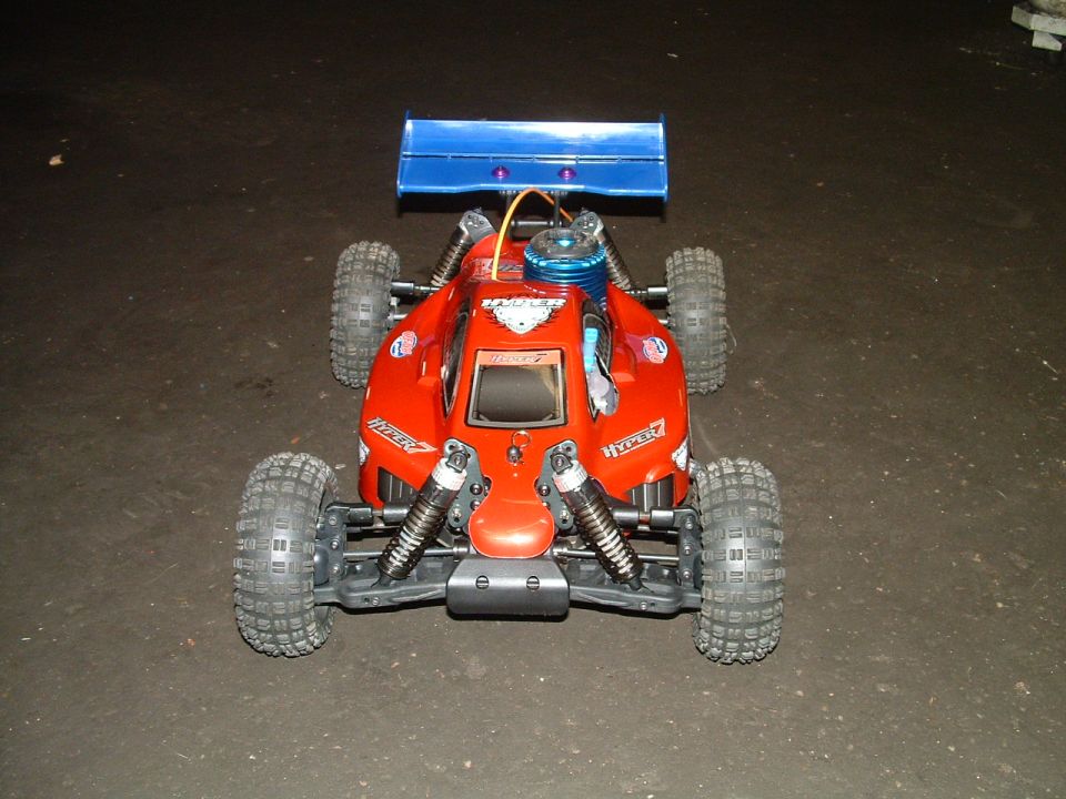 Red remote control buggy with blue spoiler and visible engine. Text 'HYPER' visible on sides