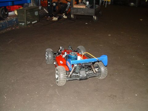 1994 Ford Bronco - A red and blue remote control car with a prominent rear spoiler sits on a concrete surface.