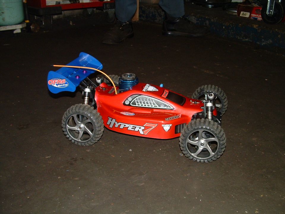 Red remote control buggy with blue spoiler and "HYPER 7" text