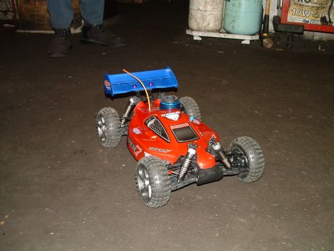 1994 Ford Bronco - A red remote control buggy sits on a concrete floor, ready for action.