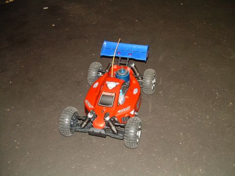 1994 Ford Bronco - This remote control buggy has a blue spoiler and a visible engine. The text 'SUPERMOTORS' is visible in the lower right corner.