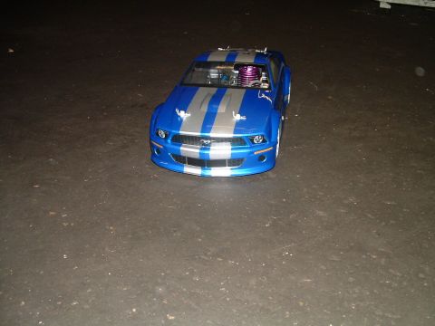 1994 Ford Bronco - A blue and silver remote control car with racing stripes is displayed on a dark surface.