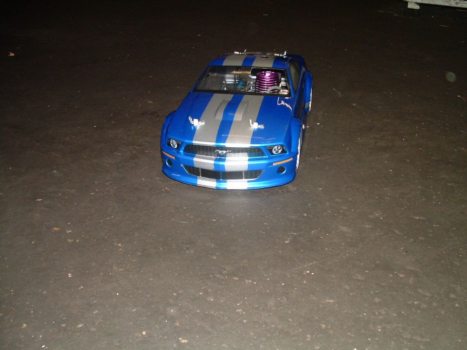 Blue and silver remote control car with racing stripes and visible engine components