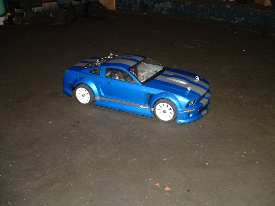 Blue remote control car with silver stripes on a dark surface