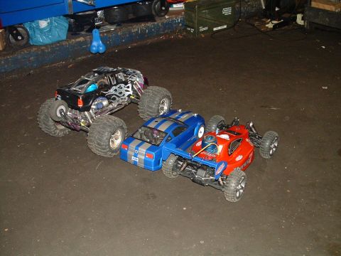 1994 Ford Bronco - Three remote control cars are parked on a concrete floor in what appears to be a workshop or garage.