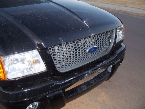 2003 Ford Ranger - Front view of a black 2003 Ford Ranger with a damaged bumper and grille.