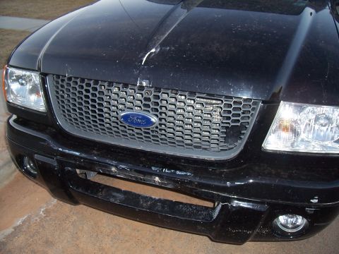 2003 Ford Ranger - The front grille and headlights of a black Ford truck are shown in this close-up photo.