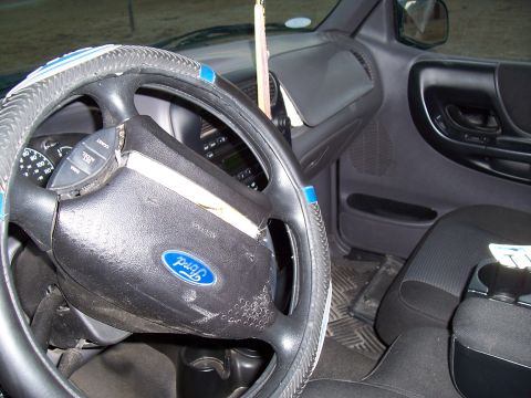 2003 Ford Ranger - The interior of a 2003 Ford Ranger, the steering wheel, dashboard, and driver's side door.