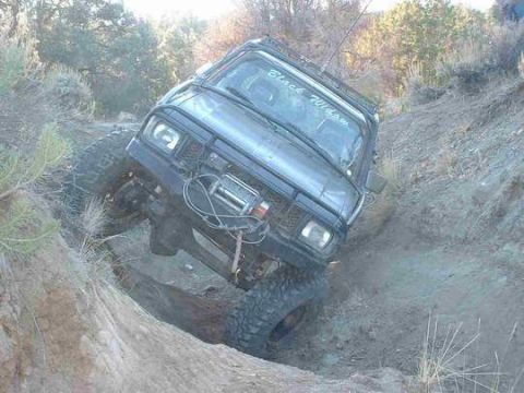 1986 Ford Bronco - This modified SUV, labeled "Black Widow," tackles a challenging off-road obstacle.
