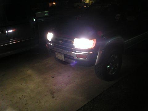 1996 Toyota 4Runner - Front view of a 1996 Toyota 4Runner at night, headlights illuminated. Another vehicle is parked alongside.