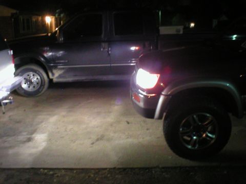 1996 Toyota 4Runner - A dark 1996 Toyota 4Runner is parked next to another SUV at night.