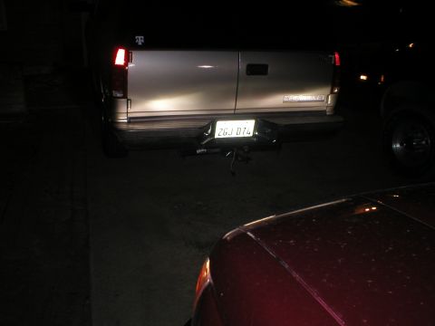 1996 Toyota 4Runner - Silver Chevrolet van's rear end is visible, with a license plate and a red car in front.