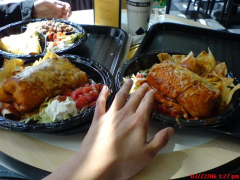 1997 Ford Probe - A meal of burritos and chips is served at a restaurant with a hand reaching into the frame.