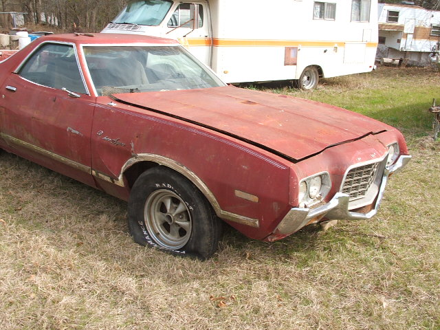 Red 1972 Ford Ranchero with flat tire and dented front end
