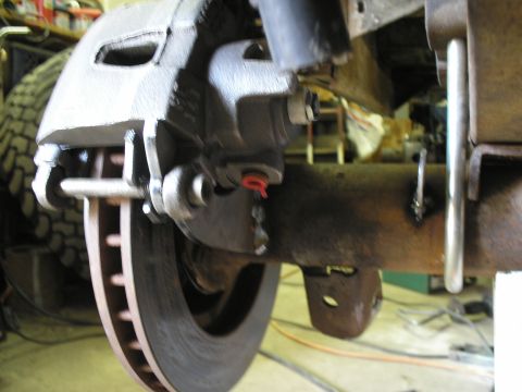 1966 Ford Bronco - Close-up view of a vehicle's brake caliper and rotor assembly, likely during a repair or upgrade.