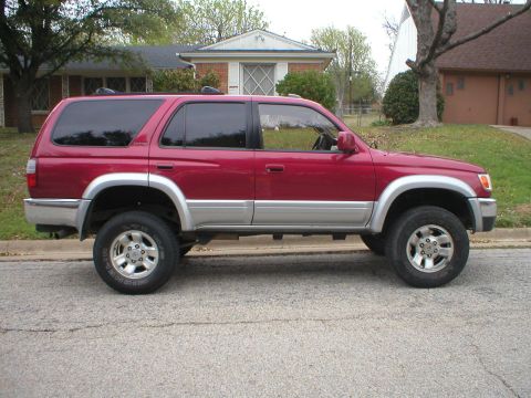 1996 Toyota 4Runner - A red 1996 Toyota 4Runner is shown from the side, parked on a residential street.