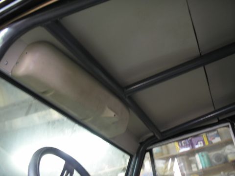 1966 Ford Bronco - The interior of a vehicle shows a metal roll cage structure installed above the headliner.