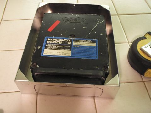 1966 Ford Bronco - A black Ford engine control computer (ECU) with a blue remanufactured-original-equipment label reading number A-4615 and calibration code 8…