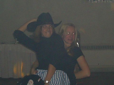 1985 Ford Bronco - Two individuals are captured in a dimly lit indoor setting, with one person sporting a cowboy hat.