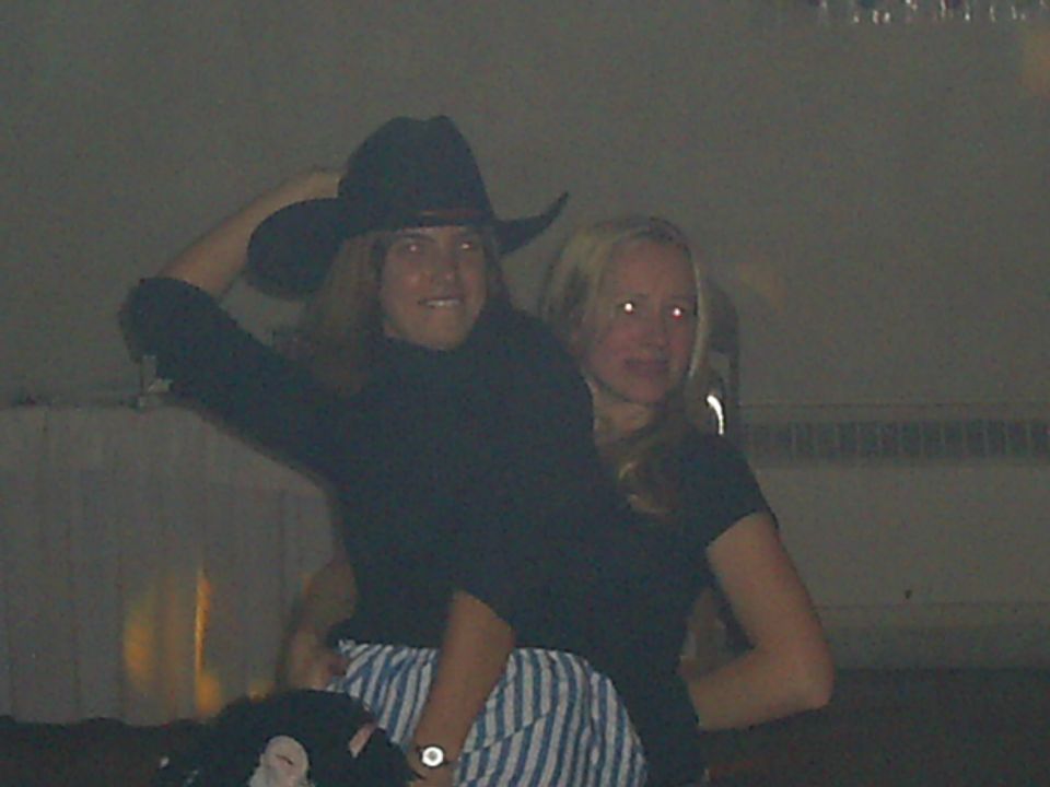 Person in cowboy hat and another person are posing for a photo indoors