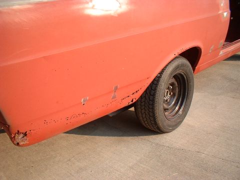 1967 Ford Ranchero - Side view of a 1967 Ford Ranchero undergoing restoration, showing rust and primer.