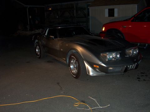 1979 Chevrolet Corvette - A gray 1979 Chevrolet Corvette is parked next to a red truck.