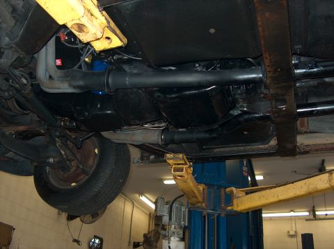1979 Chevrolet Corvette - The undercarriage of a vehicle is visible, supported by a car lift in a garage.