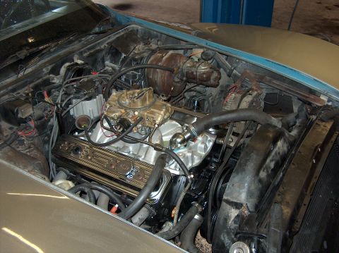 1979 Chevrolet Corvette - The engine bay of a car is shown, a V8 engine with a carburetor and associated components.