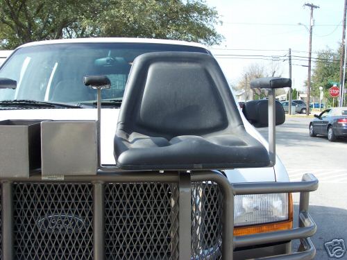 Black hunting seat and gun rests mounted on brush guard over white Ford truck grille